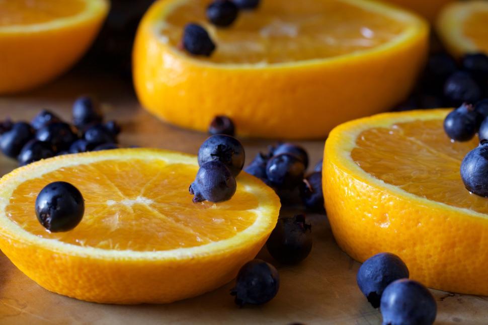 Free Image of Fresh orange slices with scattered blueberries close-up. 