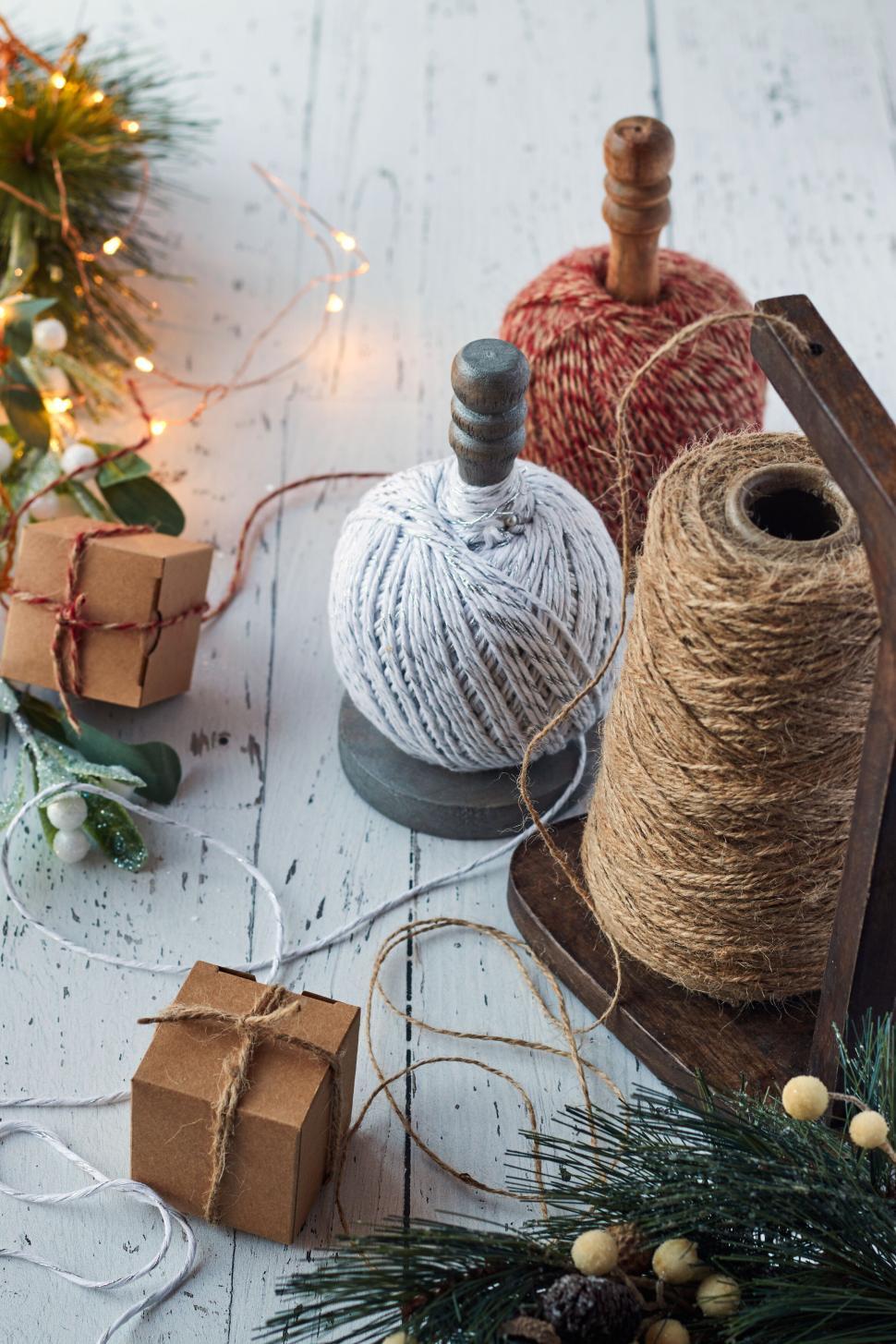 Free Image of Various threads and decorations on a rustic table 