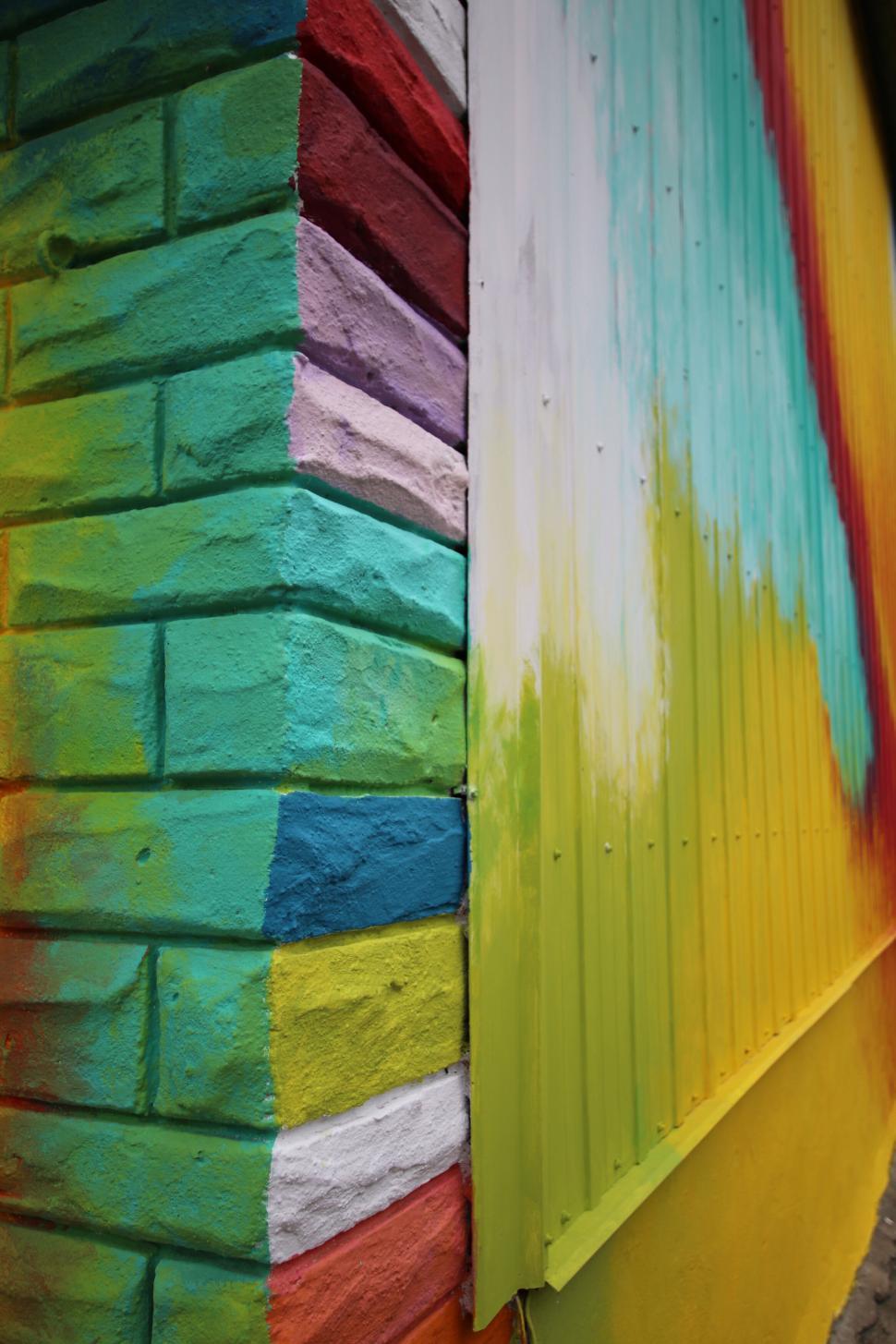 Free Image of Colorful brick wall corner with vibrant paint design 