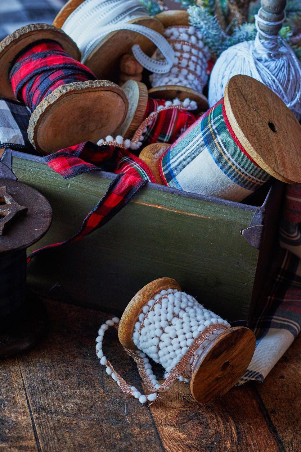 Free Image of Box with colorful fabric spools on rustic wooden table 
