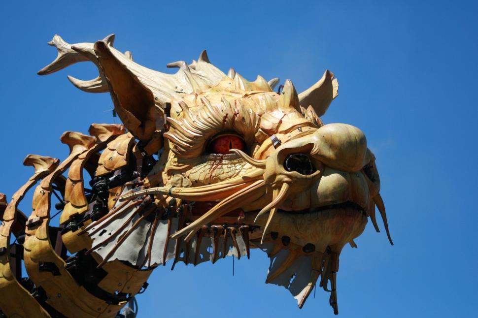 Free Image of Artistic sculpture of a dragon head against blue sky 