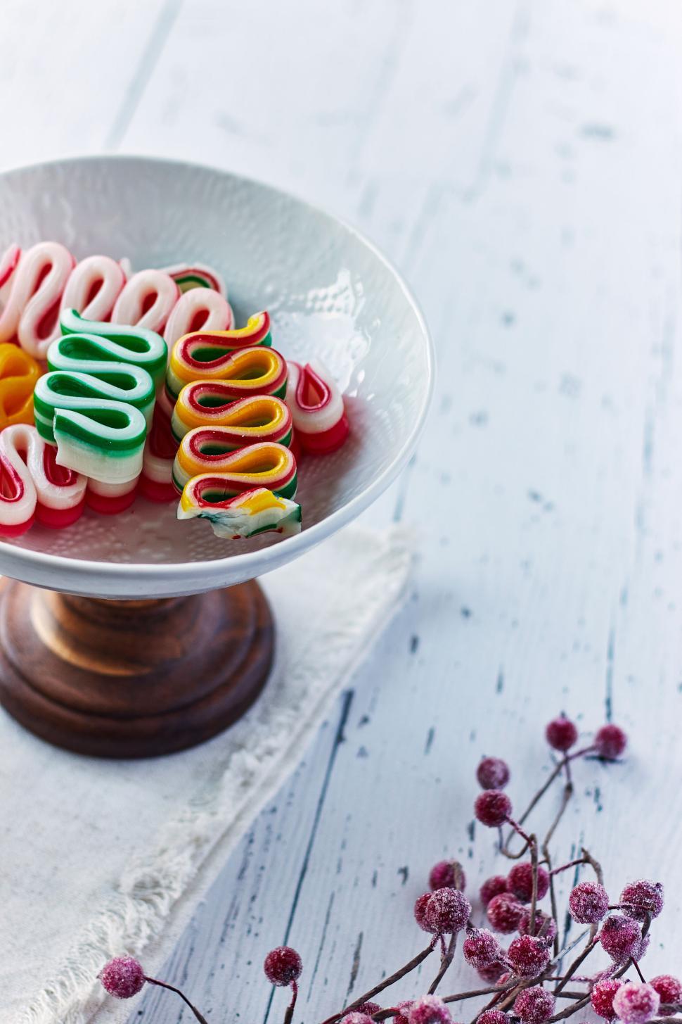 Free Image of Colorful ribbon candies on a pedestal plate with berries 