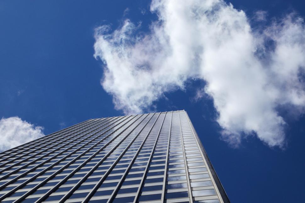 Free Image of Skyscraper extending towards a bright blue sky above 