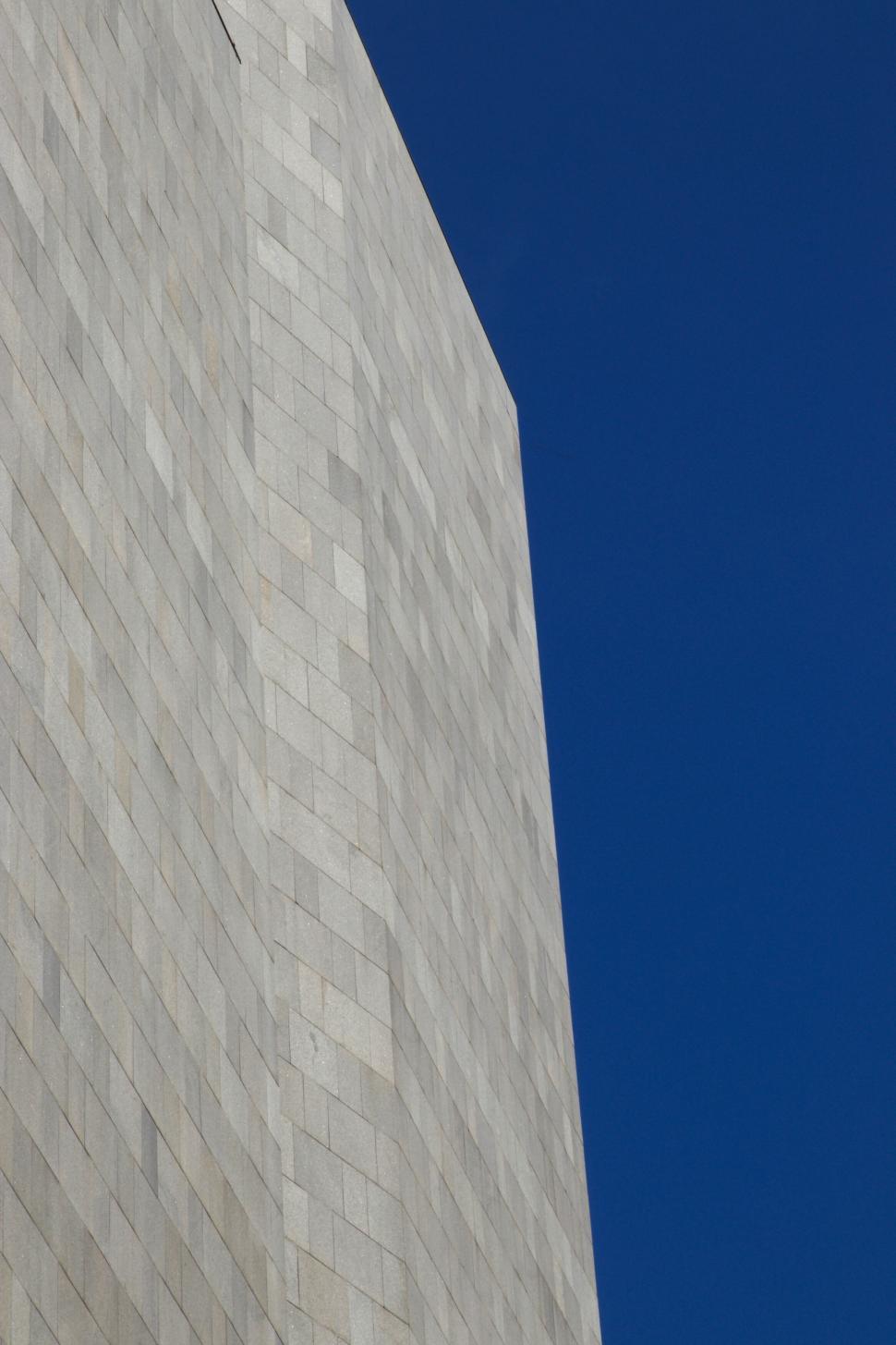 Free Image of Tall, monochromatic building structure against blue sky 