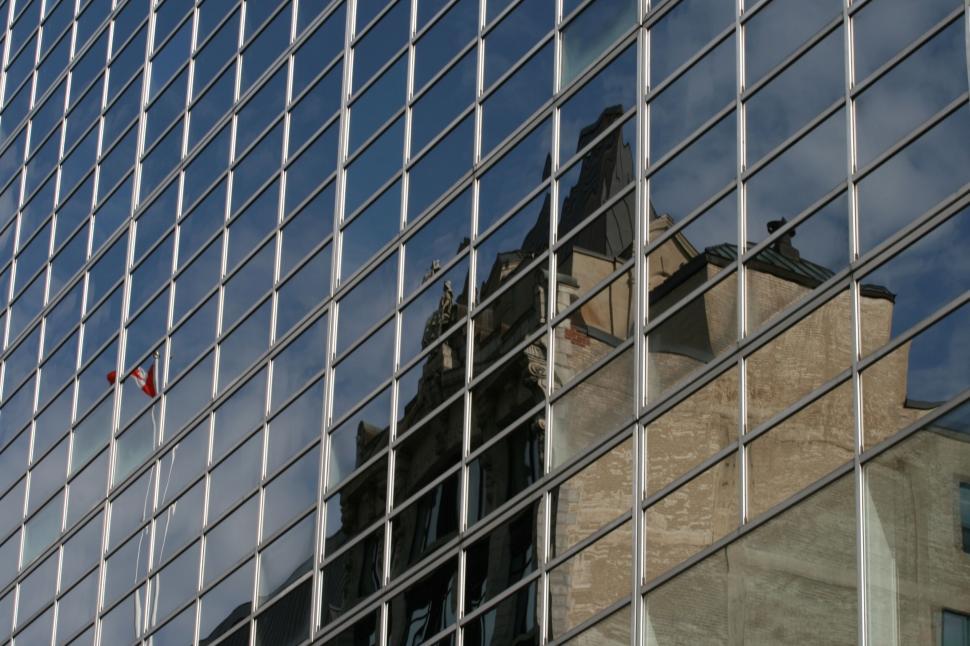 Free Image of Old building reflecting on a grid of modern glass windows 