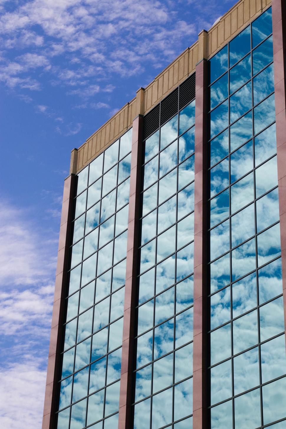 Free Image of View of modern glass building reflecting the sky. 