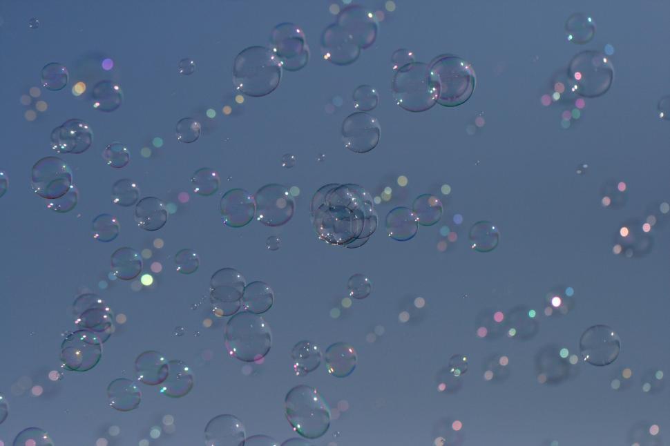 Free Image of Numerous soap bubbles floating against a clear sky. 