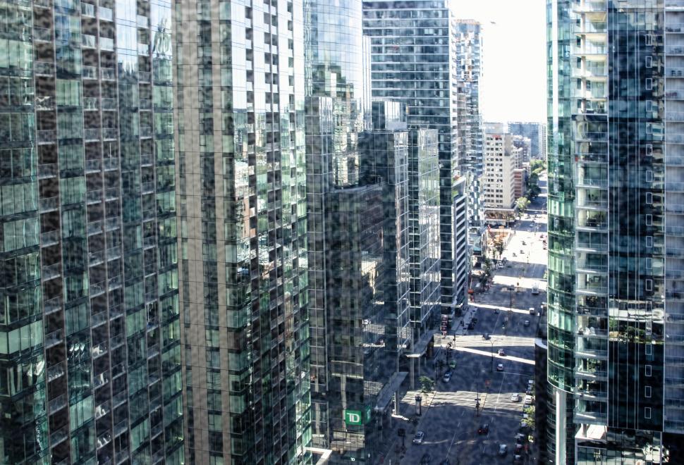 Free Image of Busy skyscraper lined city street under bright sunlight. 