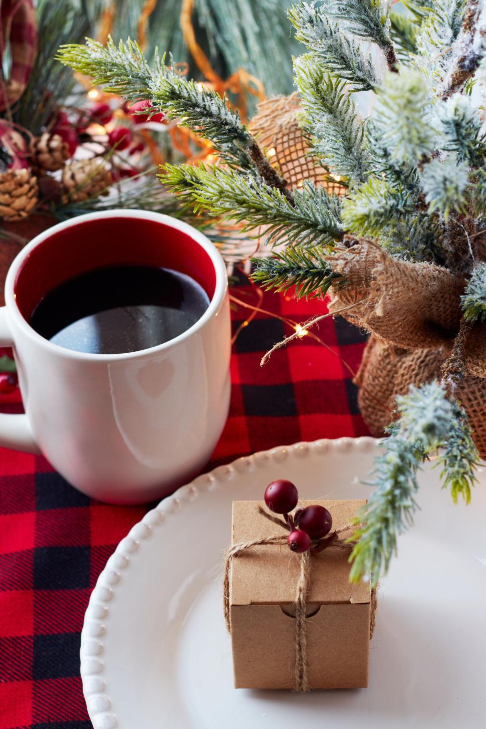 Free Image of Coffee and small gift on table with pine decor elements. 
