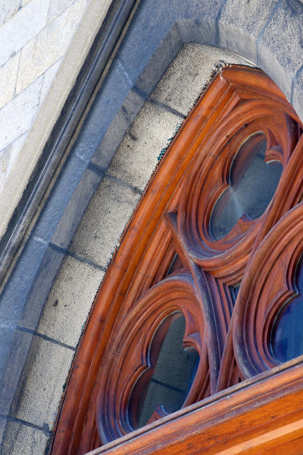 Free Image of Architectural details of a stone and wooden arched window. 