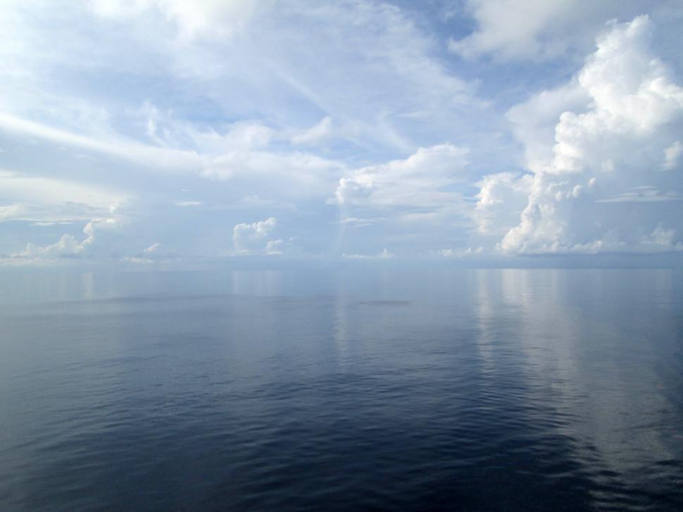 Free Image of Calm ocean with a vast sky and gentle clouds above. 