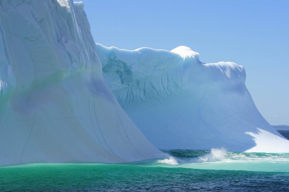 Free Image of A majestic iceberg floating in a calm blue sea. 