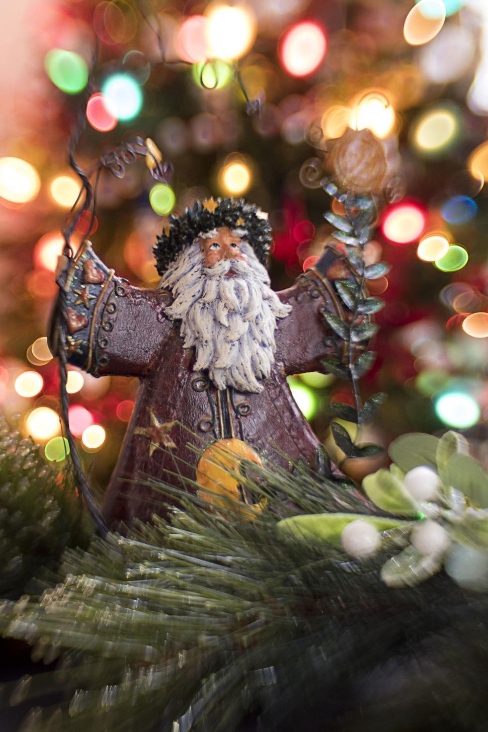 Free Image of Festive figurine surrounded by colorful holiday bokeh lights 