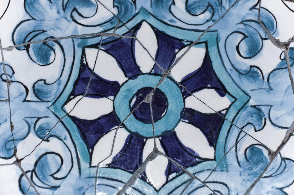 Free Image of A broken tile with artistic blue and white design patterns. 