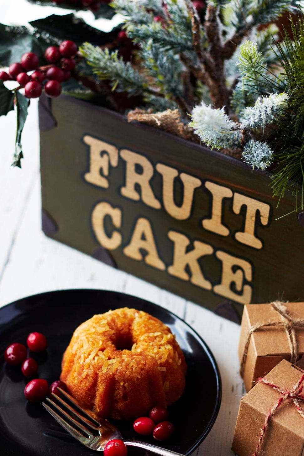 Free Image of Fruit cake and cranberries with Christmas decorations. 