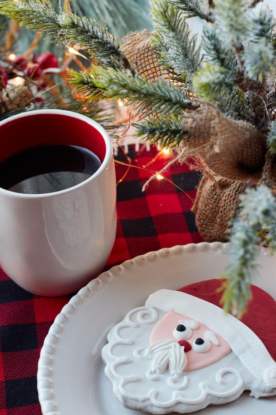 Free Image of Festive Santa-shaped cookie on a white plate with coffee. 
