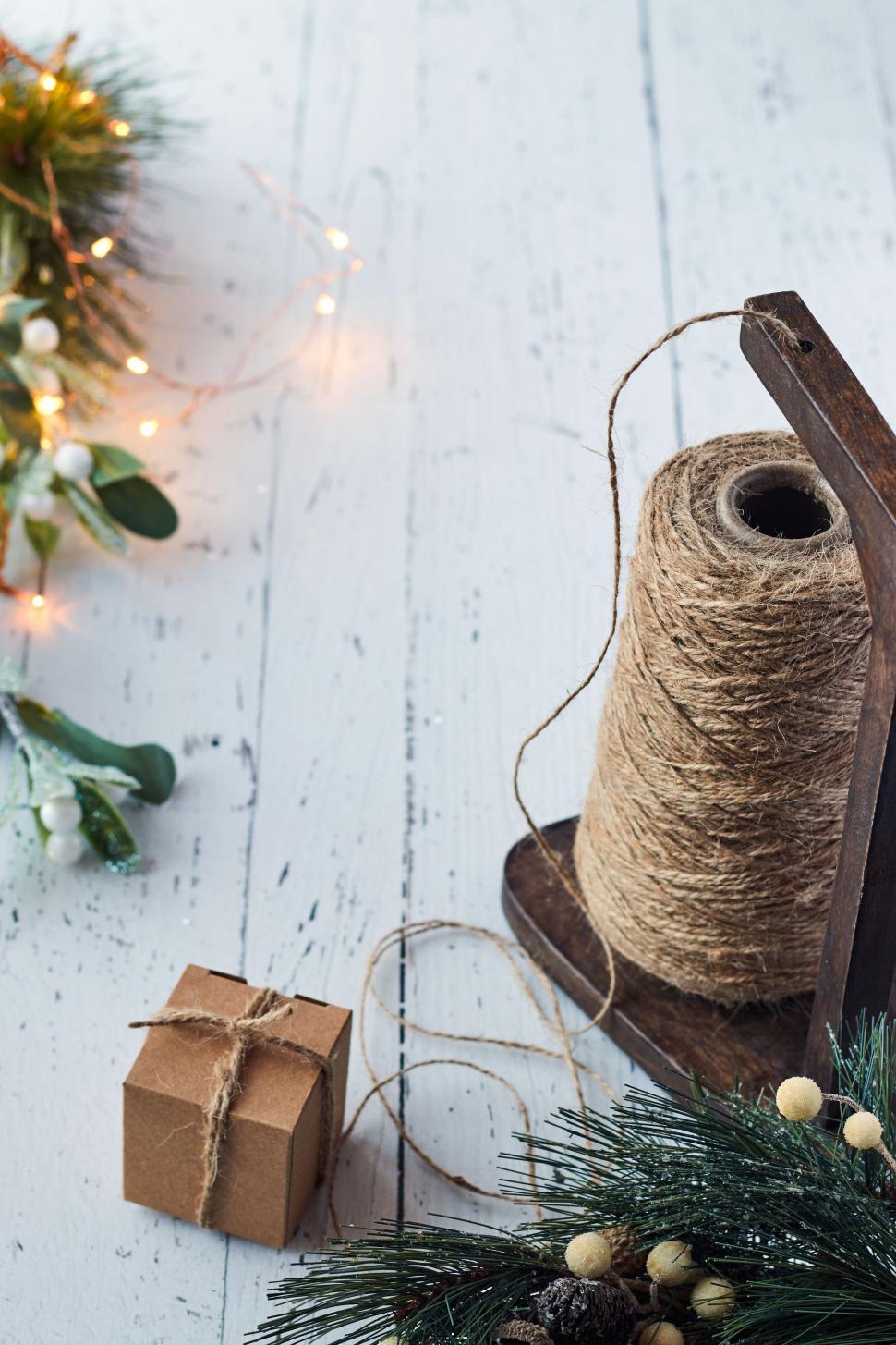 Free Image of Rustic twine spool with small gift box on wooden table. 