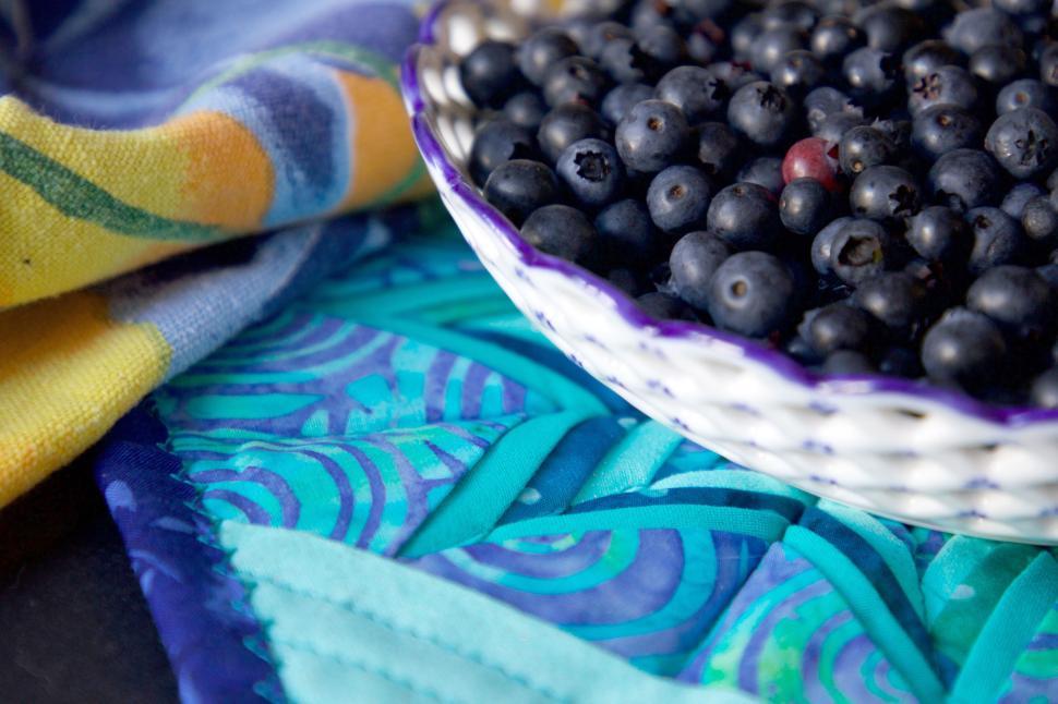 Free Image of Basket of fresh blueberries on a textured colorful cloth. 