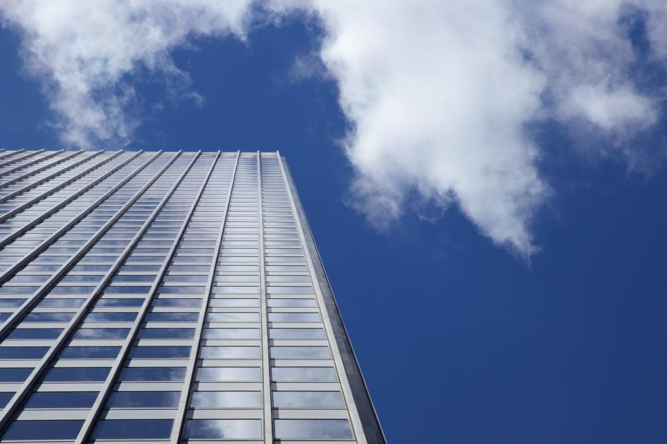 Free Image of Tall building reaching up to the blue cloudy sky. 