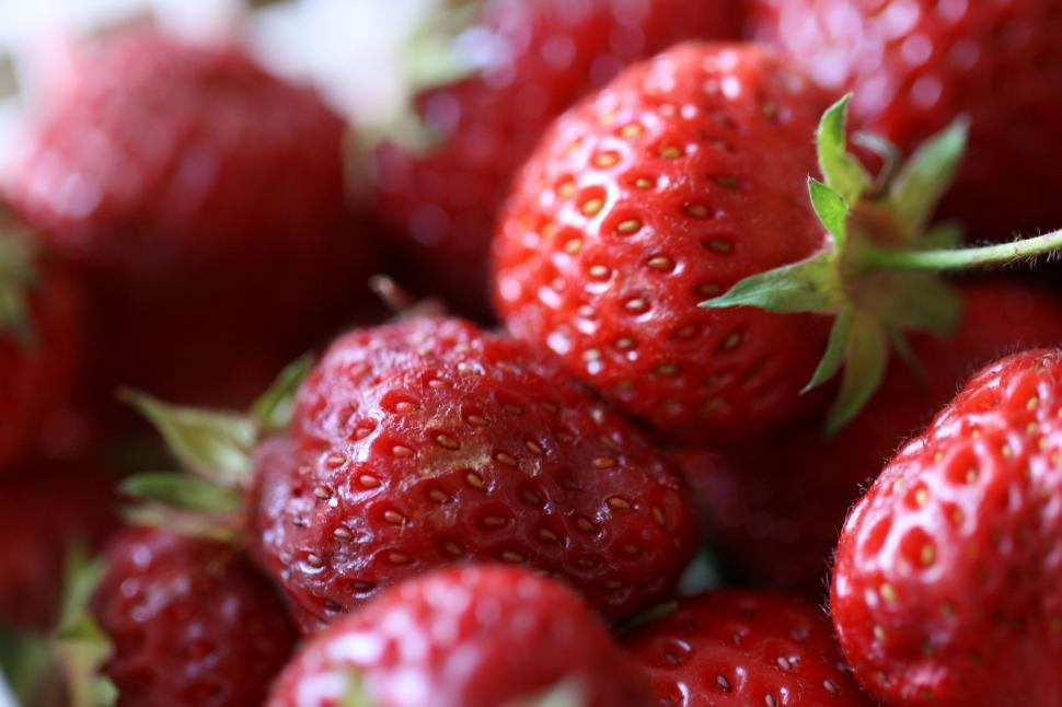 Free Image of Fresh ripe strawberries with green leaves, close-up view. 