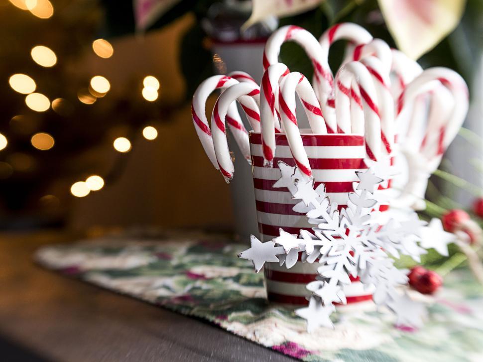 Free Image of Candy canes in a striped mug with a decorative snowflake. 