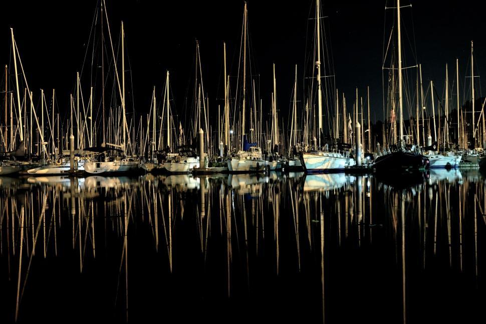 Free Image of Nighttime harbor with boats and their reflections in water 