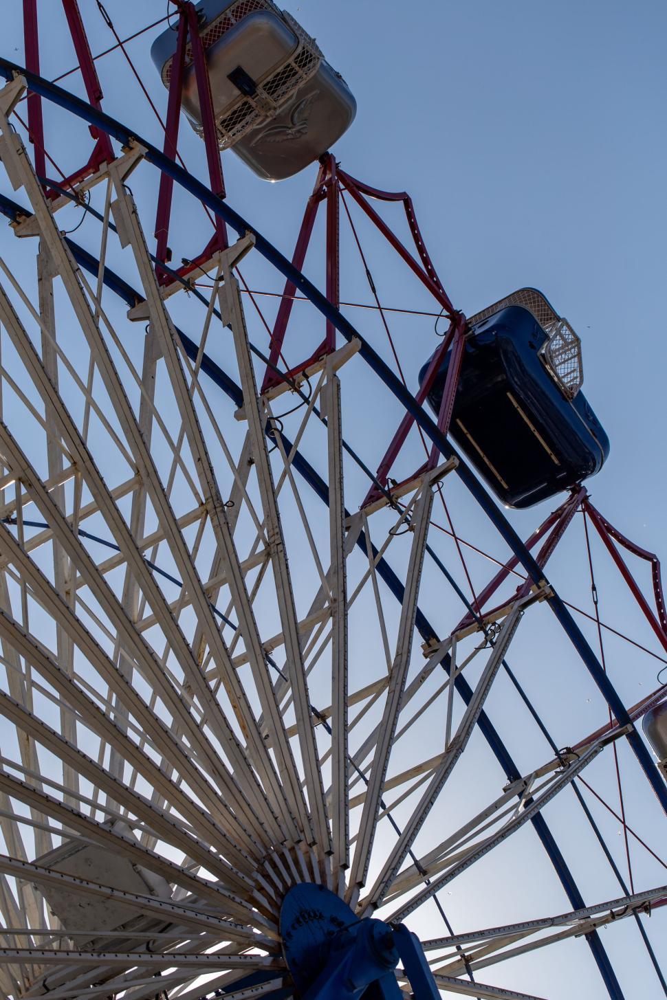 Free Image of Ferris wheel with gondolas at a fairground in daylight. 