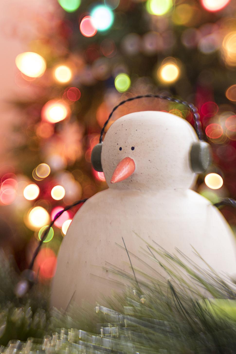 Free Image of Christmas snowman figurine with headphones on 