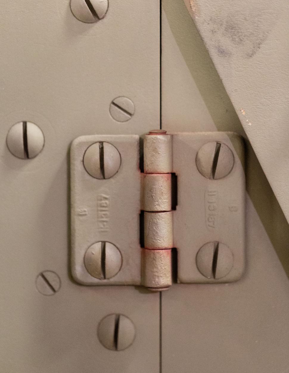 Free Image of Close-up of industrial metal door hinge with bolts. 