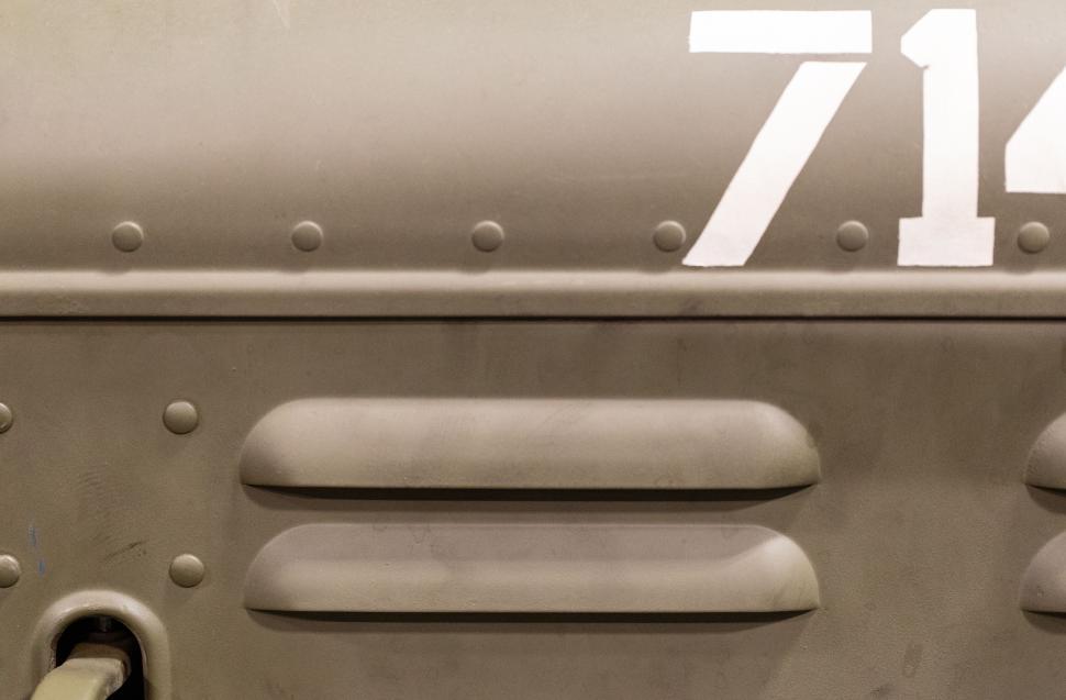 Free Image of Numbers and rivets on a military vehicle’s side panel. 