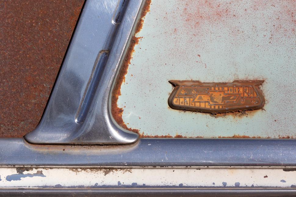 Free Image of Rusted and aged car emblem on an old classic vehicle body. 
