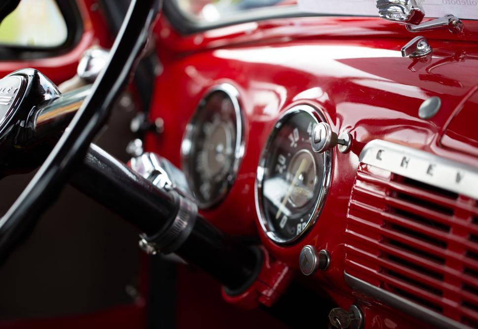 Free Image of Vintage red car dashboard with classic gauges and controls 