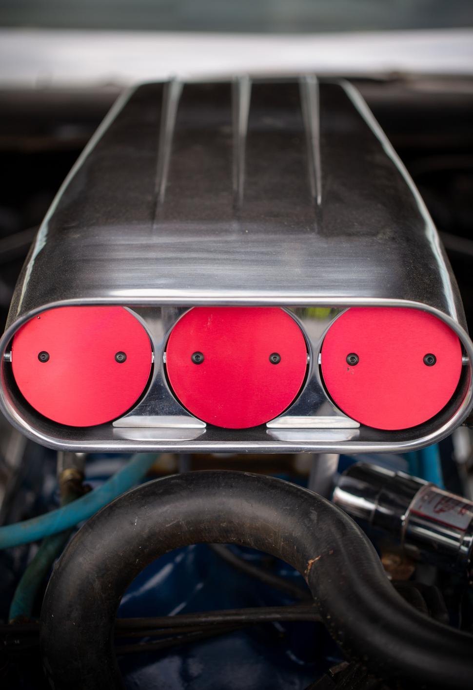 Free Image of Engine detail with exposed red air intake components 
