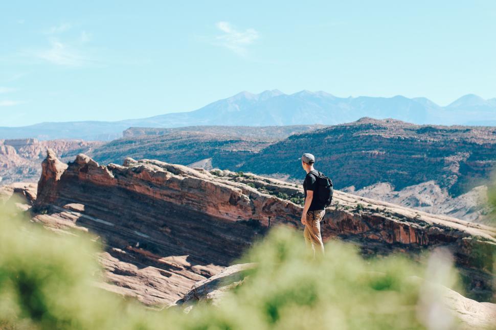 Free Image of Solo hiker admires desert valley view with mountains 