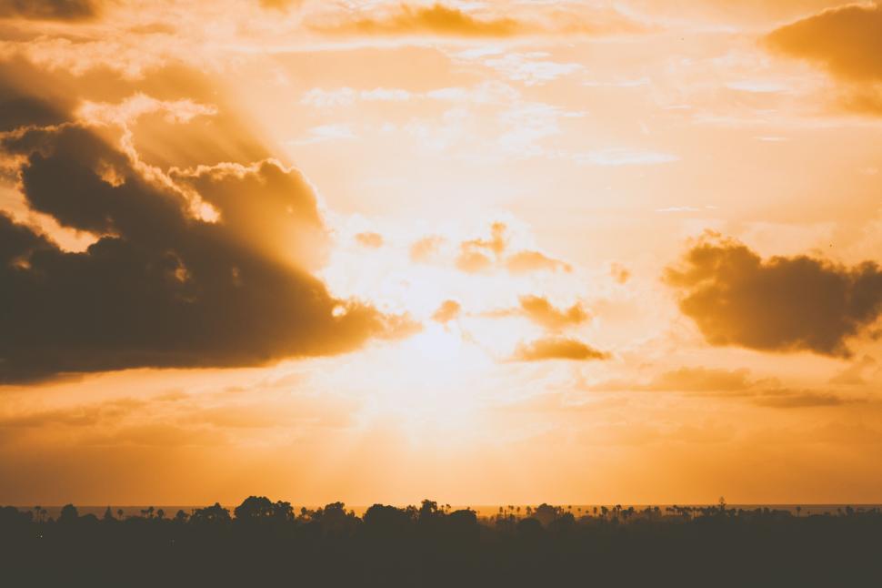 Free Image of Golden sunset with rays breaking through dark clouds 
