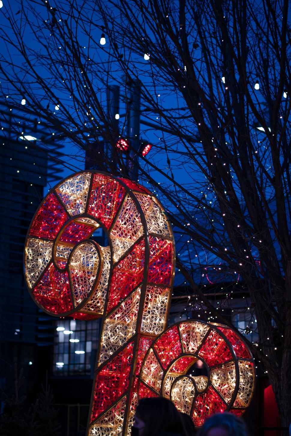 Free Image of Festive illuminated candy cane decoration at night. 