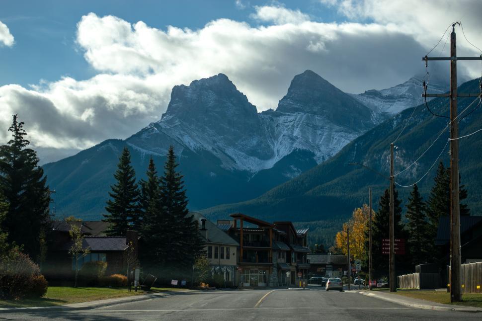 Free Image of Mountain town with snow-capped peaks in the background. 