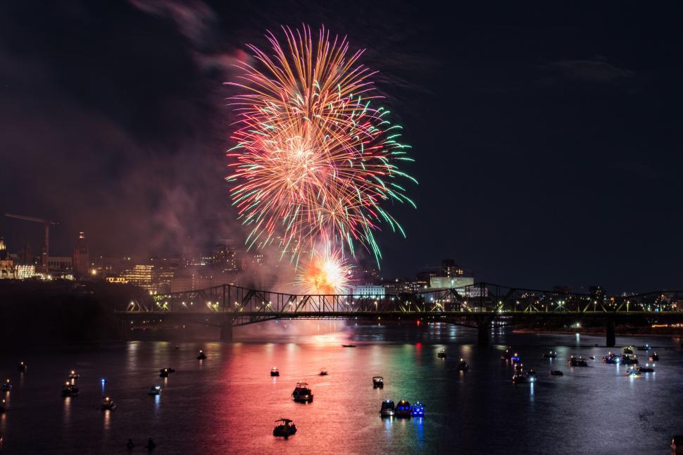 Free Image of Colorful fireworks illuminate night sky over river. 