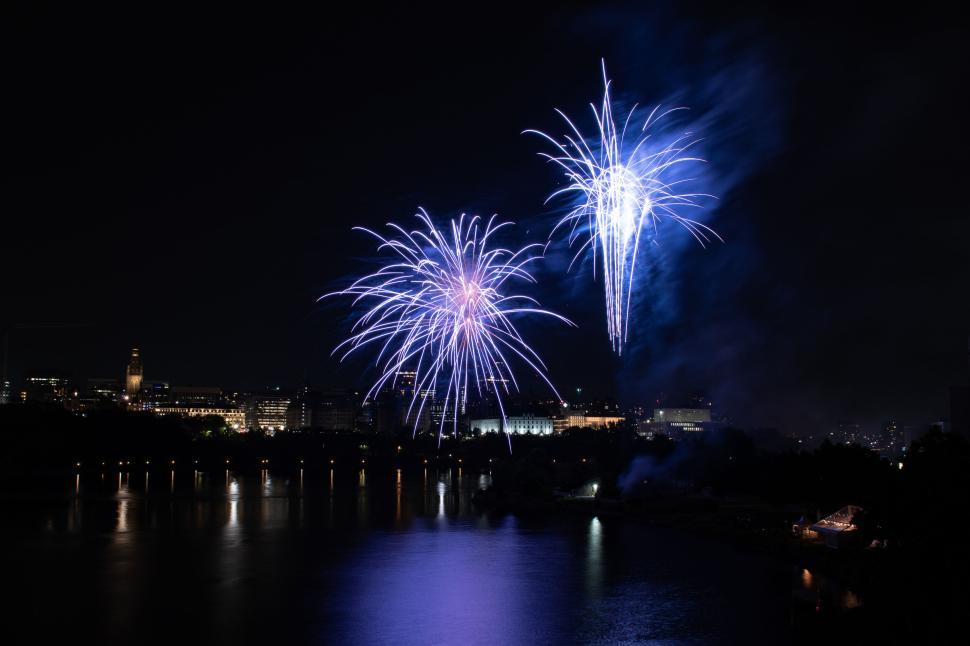 Free Image of Blue fireworks exploding over the city at night time 