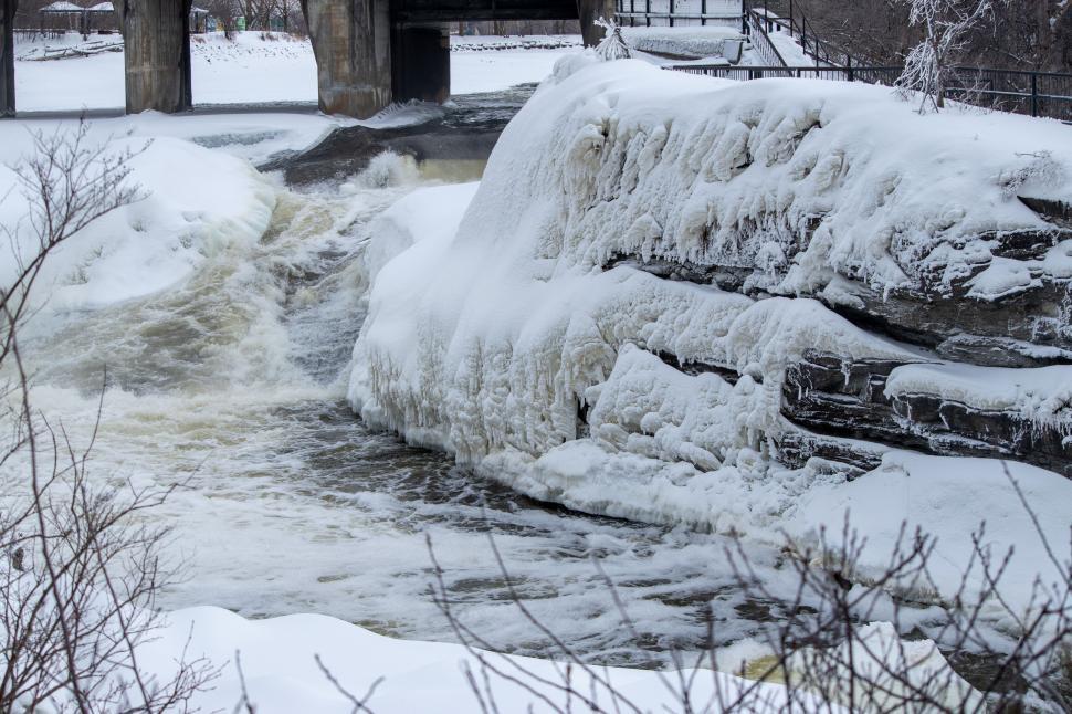 Free Image of Snow-covered waterfall with rocks, showing winter beauty. 