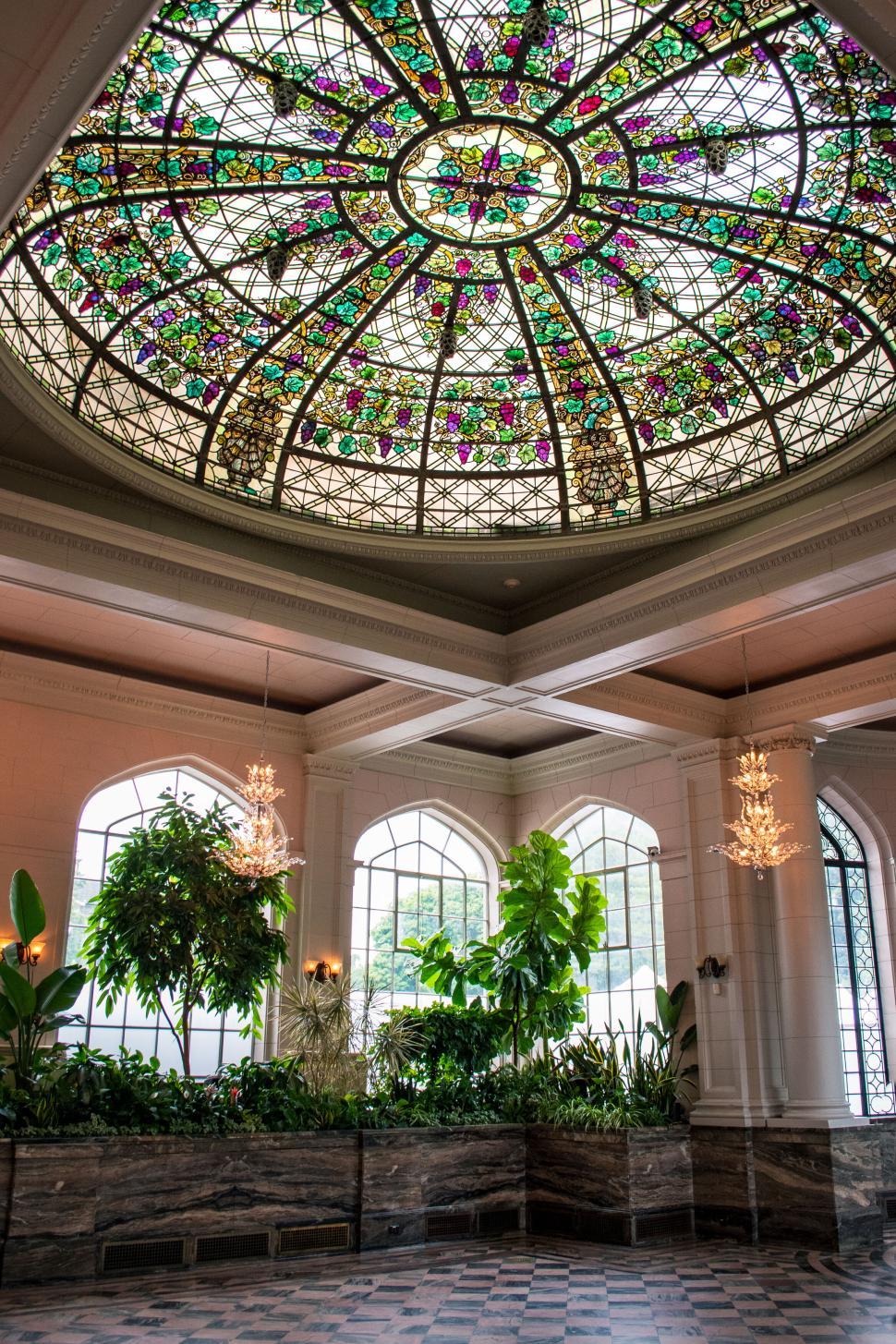 Free Image of Intricate stained glass ceiling dome in a lush atrium 