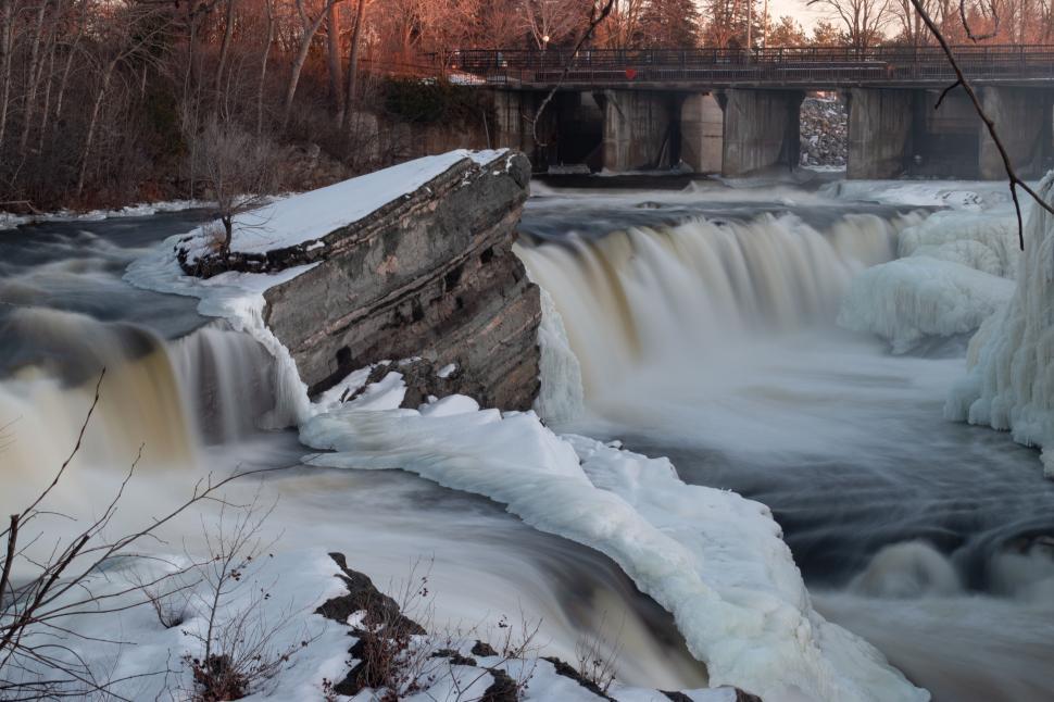 Free Image of Flowing waterfall partly frozen in winter landscape 