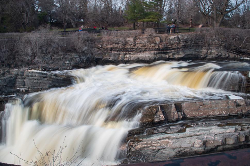 Free Image of Rushing water down rocky waterfall at park with trees 