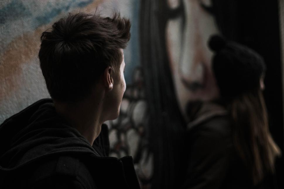 Free Image of People walking past a colorful mural painting on the wall 