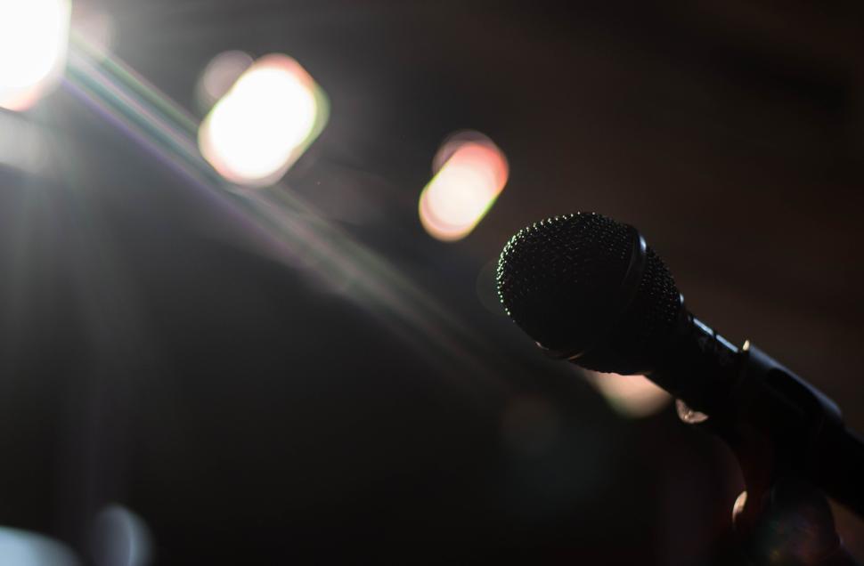 Free Image of Close-up of a microphone under spotlights on a stage. 