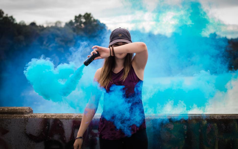 Free Image of Person with smoke grenade surrounded by blue smoke. 