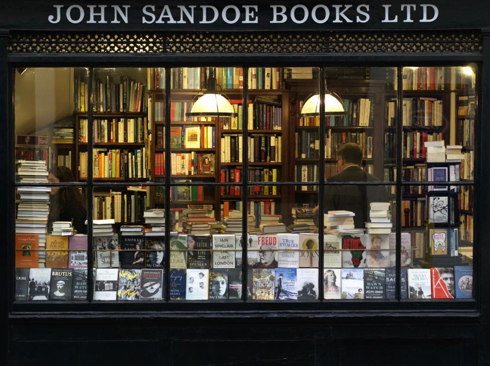 Free Image of Bookstore with various books displayed in the window. 