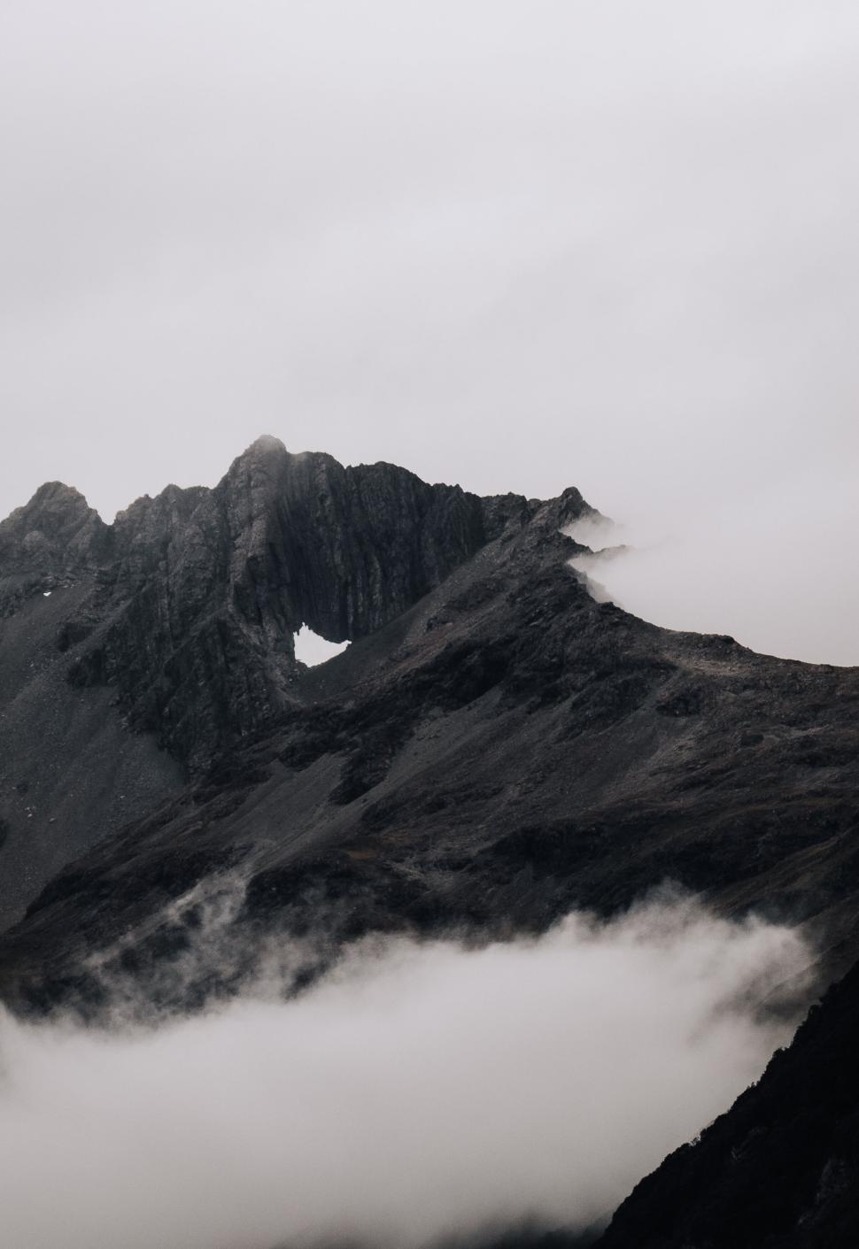 Free Image of Misty mountain peak with rocky slopes and rugged terrain. 