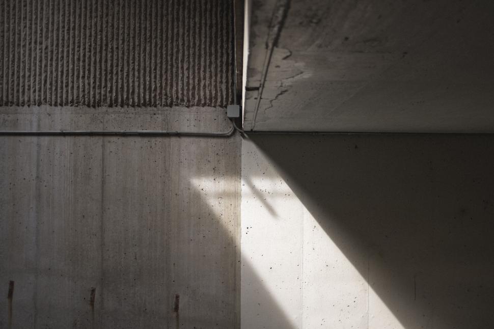 Free Image of Sunlight and shadow casting geometric patterns in tunnel. 