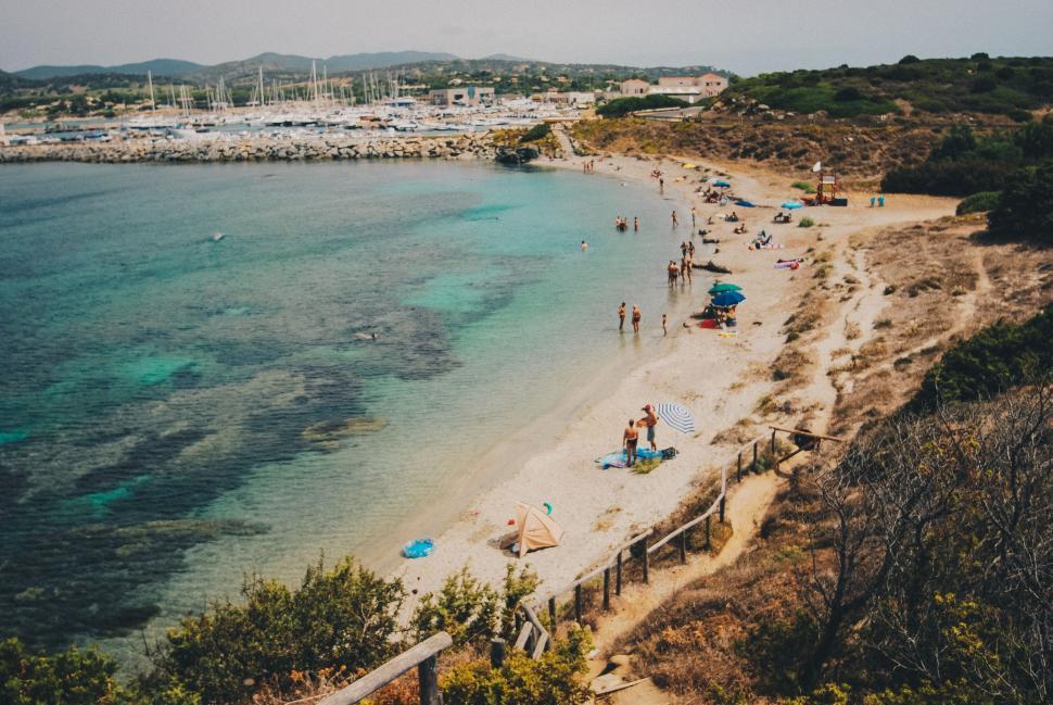 Free Image of A serene beach day with people enjoying the sunny shore 